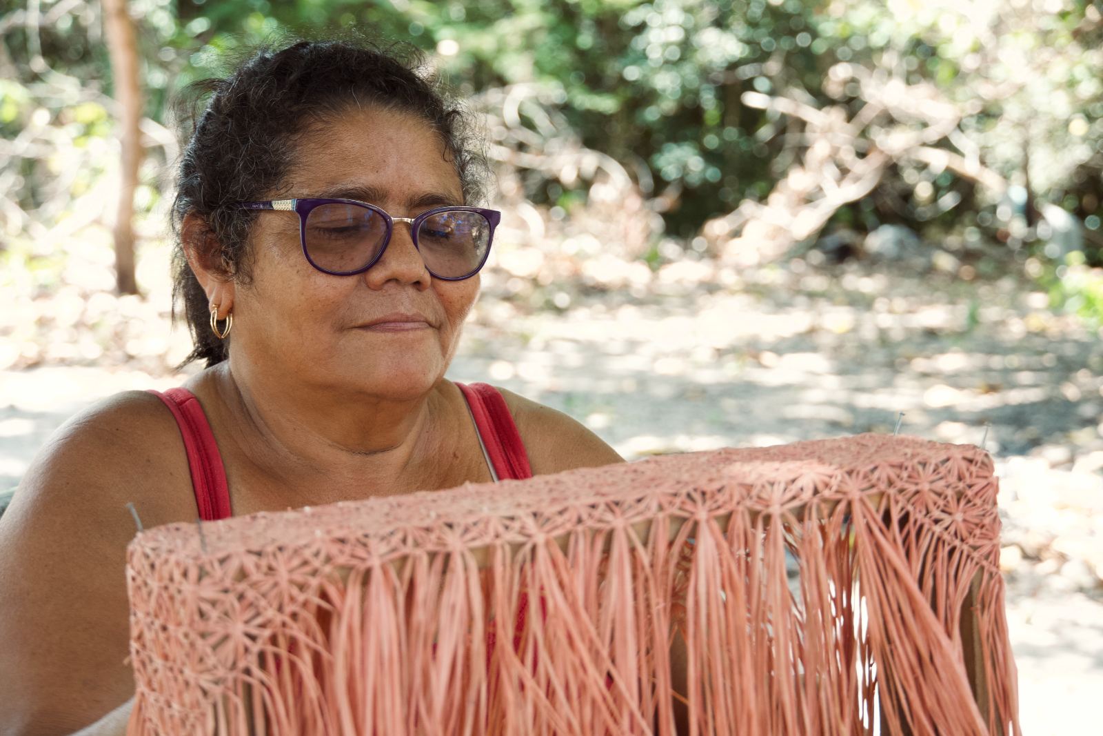 An artisan finishing a fringed piece
