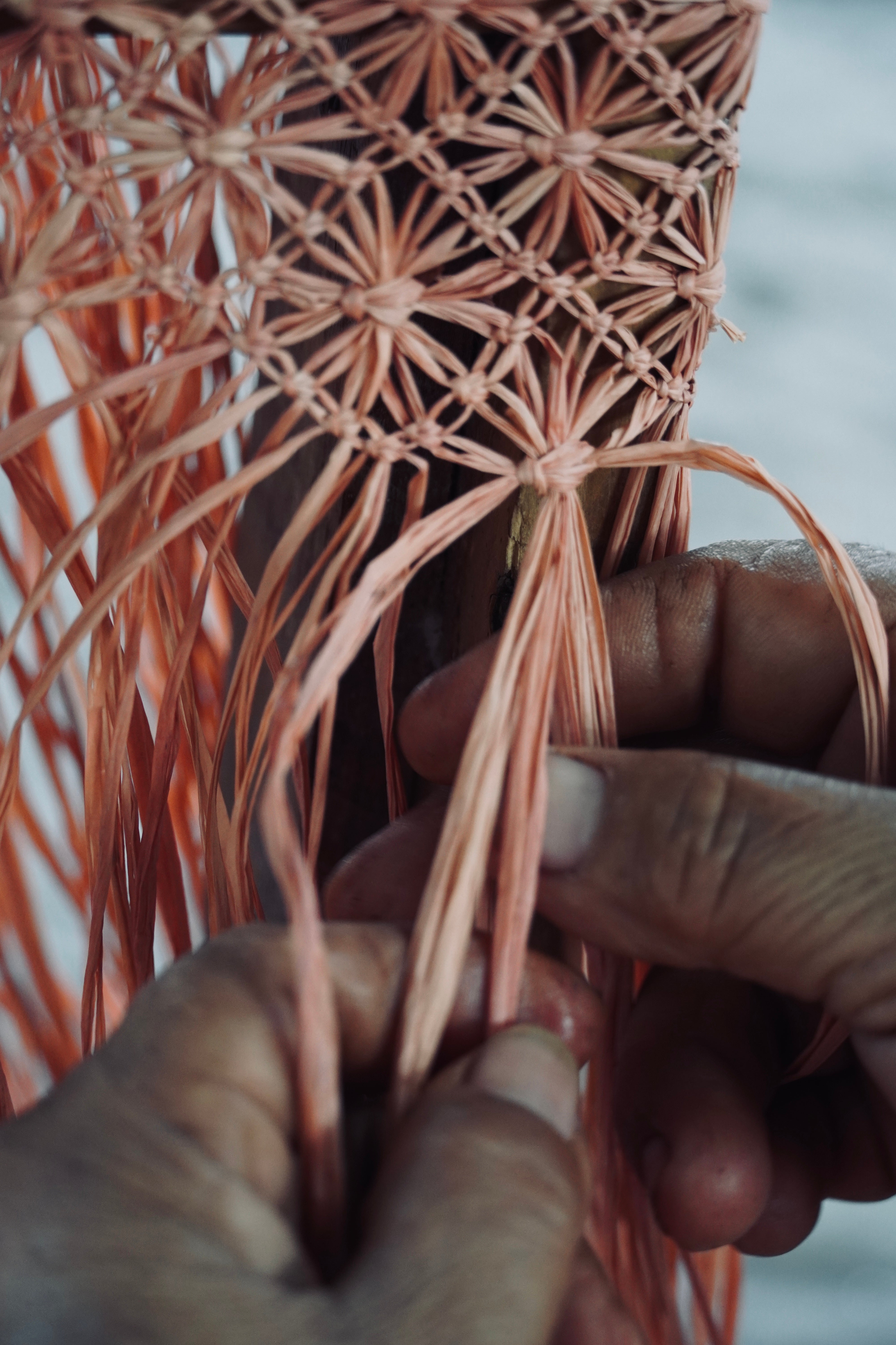 Hands knotting macramé