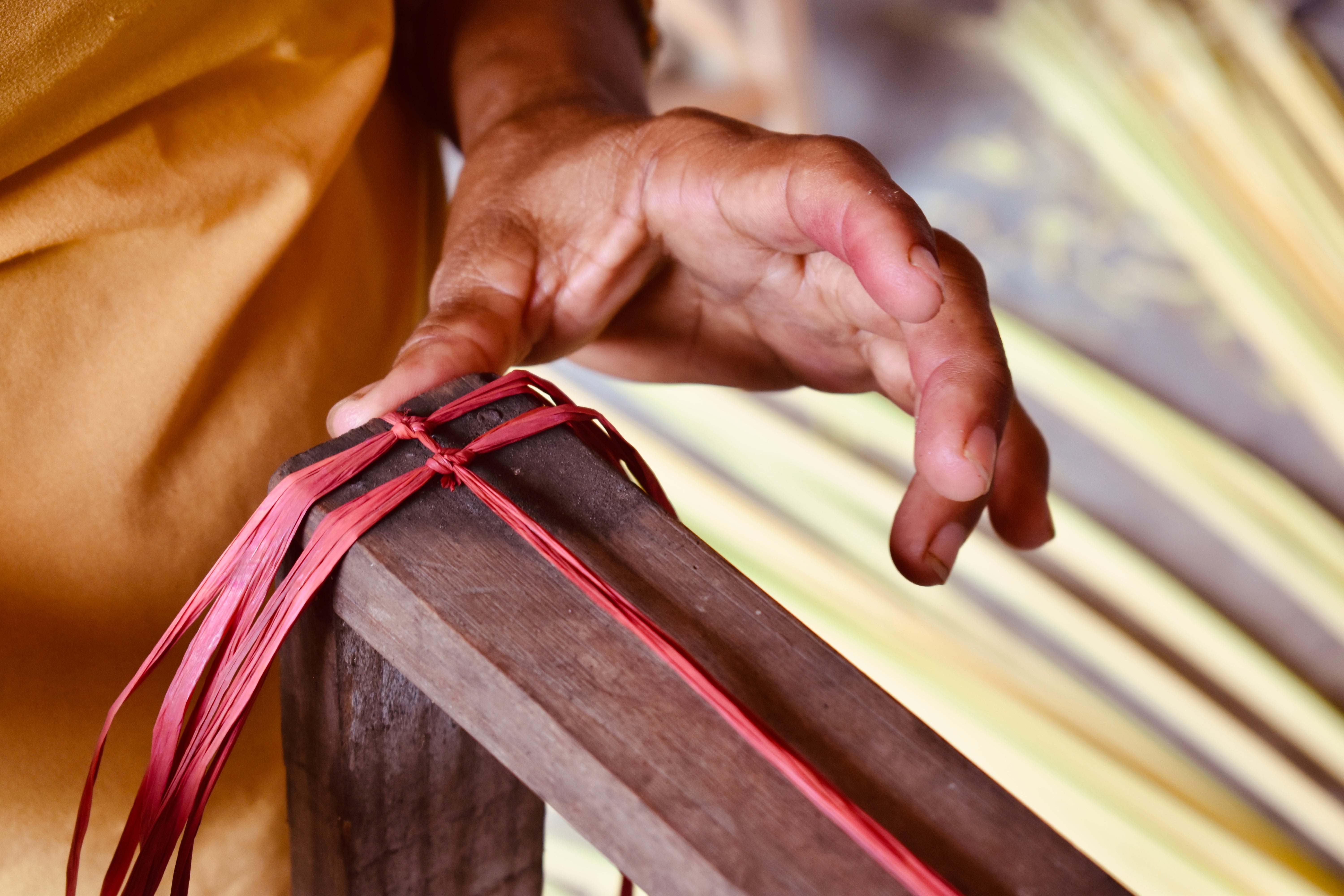 Hands tying a raffia knot