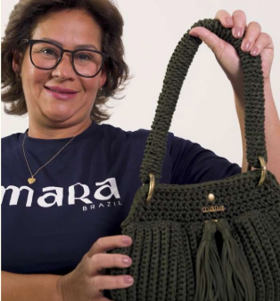 A founding artisan holding a crochet bag