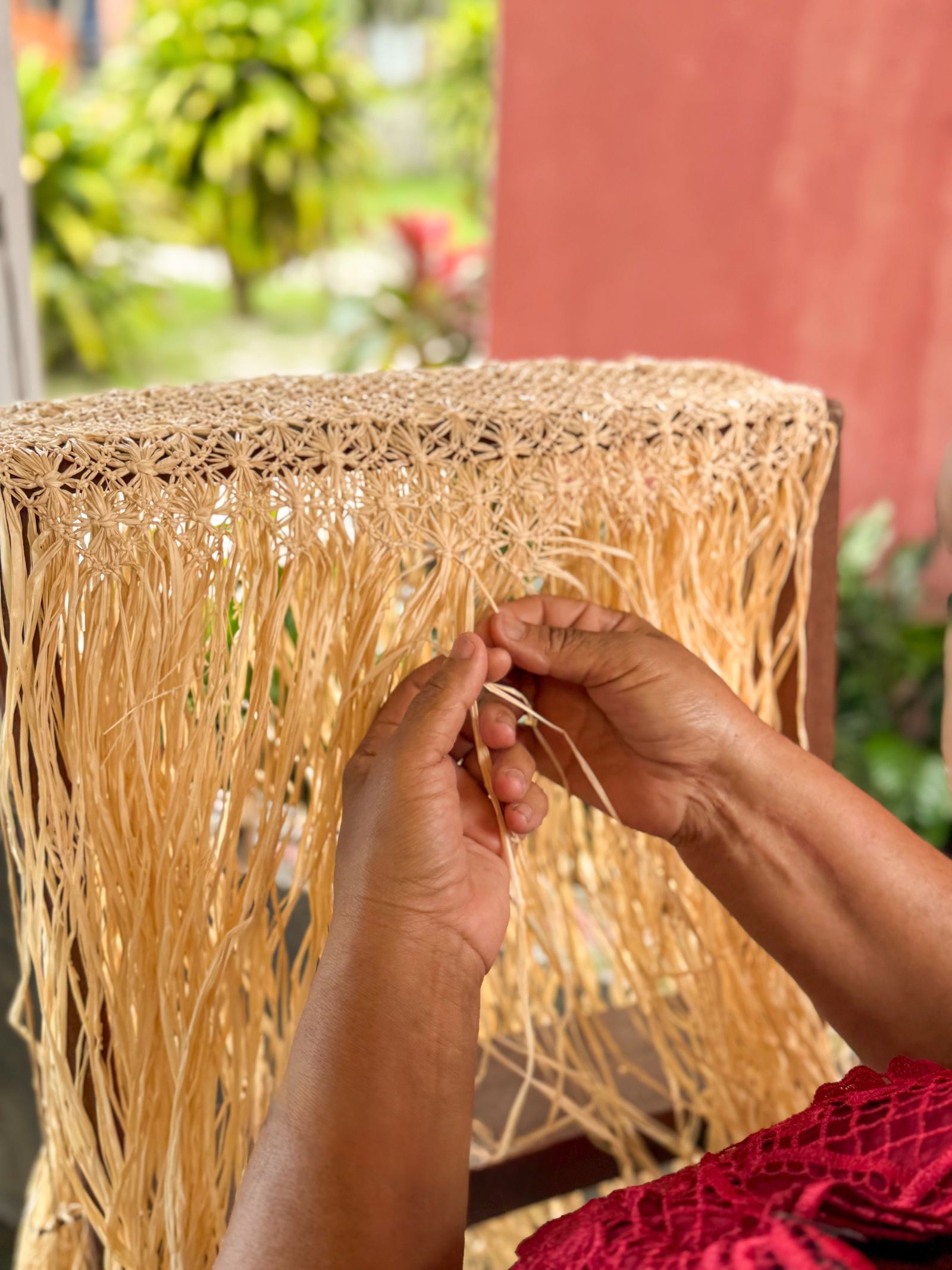 An artisan weaving a panel by hand